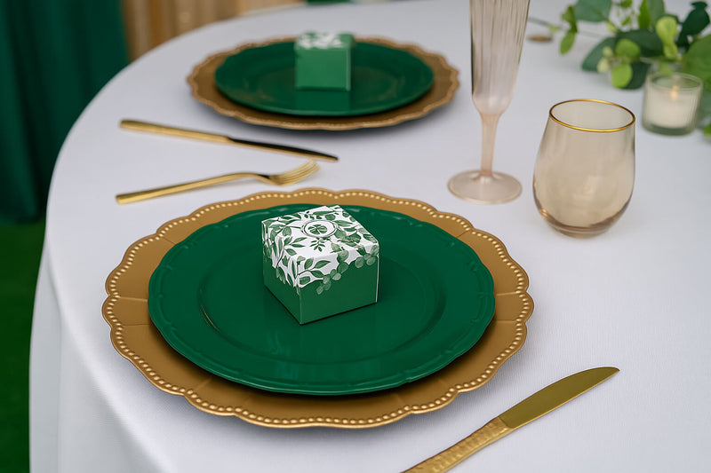 Close-up of favor box on layered plates in green and gold table decor theme.