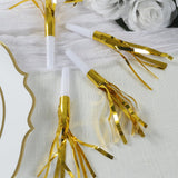 Gold foil party blowers on a textured white surface.