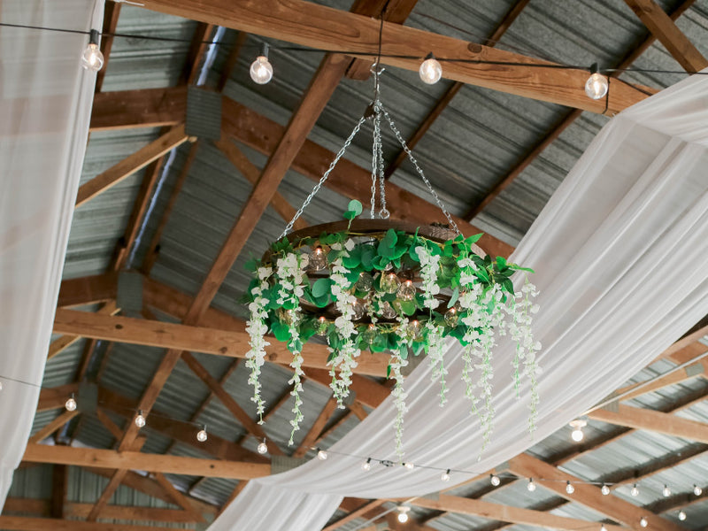 Floral chandelier hanging from a barn ceiling