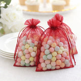 Colorful candy-filled bags in red organza, perfect for party favors.