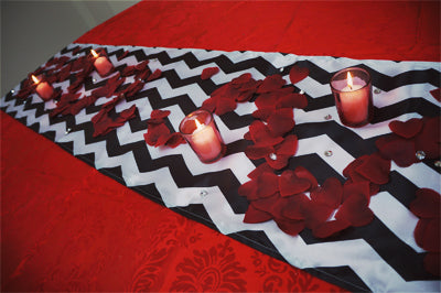 Wide view of a chevron runner with red petals and candles