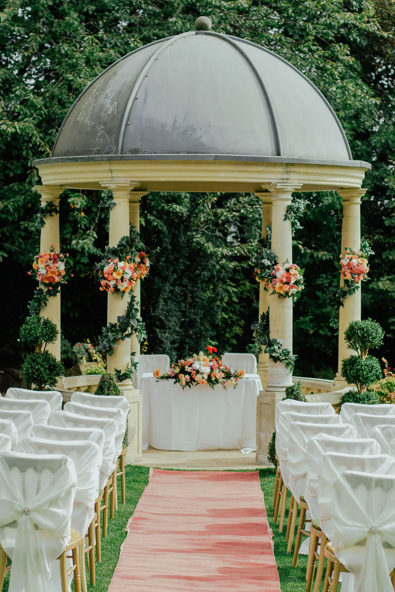 Outdoor wedding ceremony setup under a domed gazebo