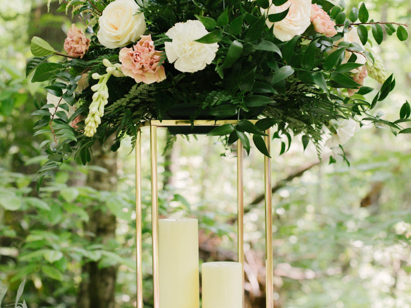 Large floral arrangement on a gold stand in a garden