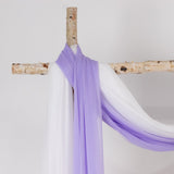 Purple and white draped fabric on a wooden stand.