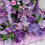 Vibrant assortment of purple artificial flowers in various shades and textures.