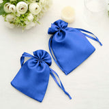 Blue satin drawstring bags on a light surface with floral decor.