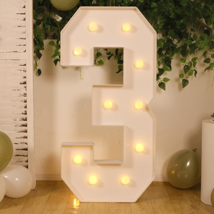 Large illuminated number three decoration with lights.
