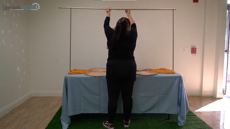 Person assembling a table arch stand
