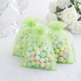 Colorful decorative candy bags in green mesh, filled with pastel balls.