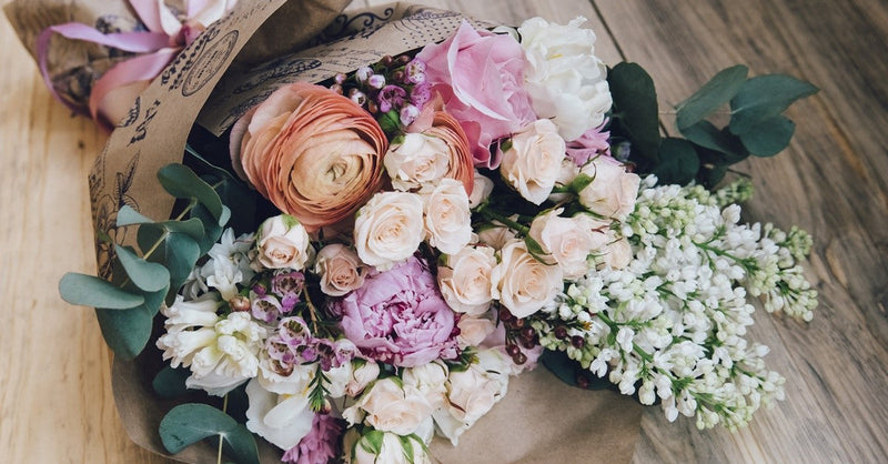 Rustic artificial flowers wrapped with paper on wood