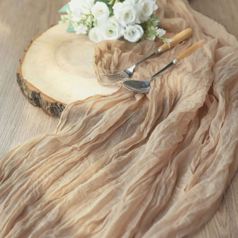 Beige gauze table runner draped over wood