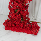 Vibrant red flower arrangement with roses and blooms on a white backdrop.