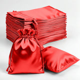 Red satin drawstring bags and flat bags on a plain background