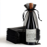 Dolcino wine bottle wrapped in black tulle with a stacked backdrop