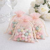 Pastel candy-filled bags tied with pink ribbons, perfect for events or favors.