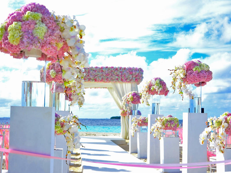 Beach wedding arch with pink and white floral arrangements