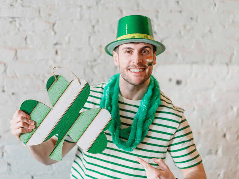 Man holding a green shamrock sign