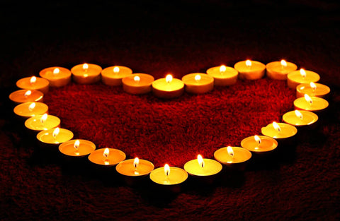 Heart of candles around red petals