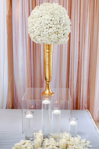 Acrylic box with white flowers and candles on a table