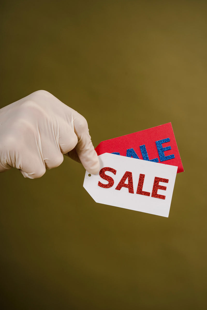 Gloved hand holding sale tags