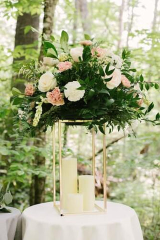 Gold flower stand with floral arrangement and candles