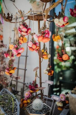 Pink blossoms and a blue bird ornament hanging by chain
