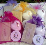 Handmade soaps and creams in colorful organza bags, featuring raspberry and lavender scents.