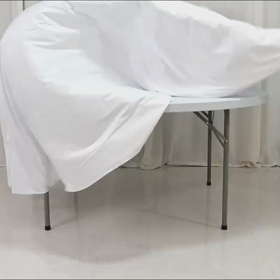 White fire retardant scuba tablecloth on a round table, wrinkle-free and seamless.