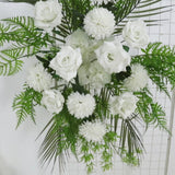Ivory rose and chrysanthemum wedding arch flowers with greenery and palm leaves.