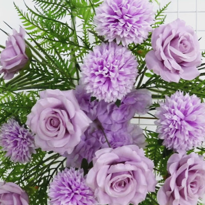 Lavender lilac rose and chrysanthemum flowers with greenery.
