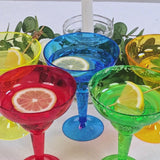 Assorted colored plastic margarita glasses with lemon slices for parties.
