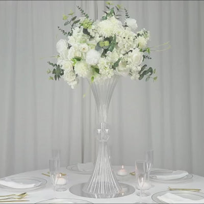 Clear ribbed acrylic trumpet vase with white floral arrangement centerpiece.