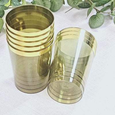 Dusty sage green plastic tumbler cups with gold rim, stylish disposable party glasses.