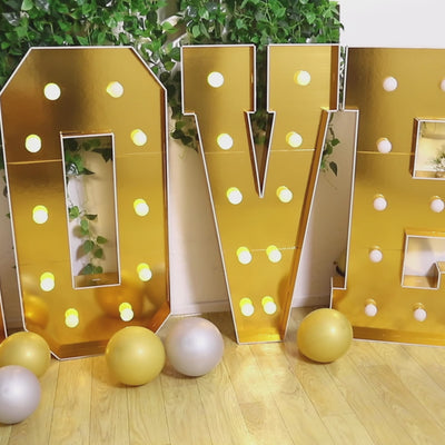 Gold LED marquee letter "N" with warm white lights and decorative elements.