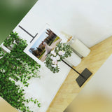 Gold metal easel stand displaying artwork with floral arrangement.