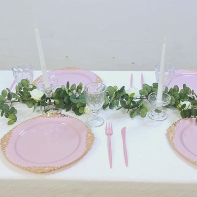 Blush round charger plates with gold embossed rim on a stylish dinner table.