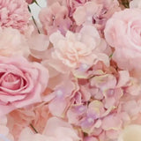Dusty rose silk flower table runner with mixed roses, hydrangeas, and peonies.