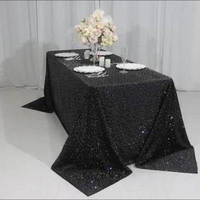 Black rectangular tablecloth with rhinestone accents on a decorated table.