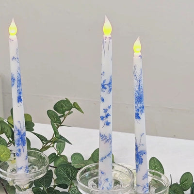 White and blue flameless LED taper candles in glass holders.