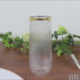 Clear ribbed stemless champagne flute with gold rim.