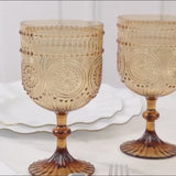 Amber gold vintage plastic wine goblets with embossed floral pattern.