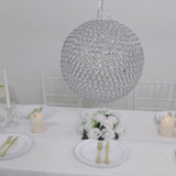 Silver crystal globe chandelier pendant hanging above a dining table setting.