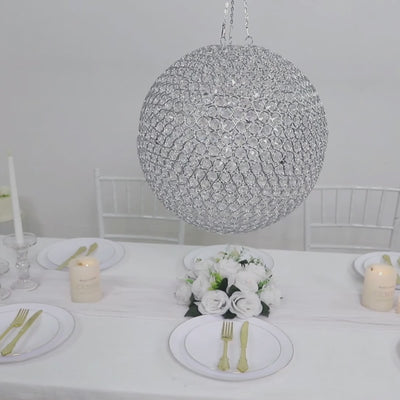 Silver crystal globe chandelier pendant hanging above a dining table setting.