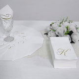 White napkins with gold foil monogram "A" for elegant dining.