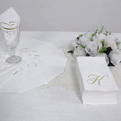 White napkins with gold foil monogram "A" for elegant dining.