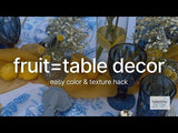 Colorful table decor featuring fruits and flowers for a vibrant dining setting.