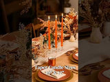 Taper candles in orange, sizes 10" & 12", on a beautifully set dining table.