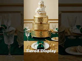 Elegant tiered cake display with gold accents and green table settings.