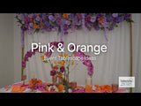 Pink and orange floral-themed event tablescape with decorative elements and settings.