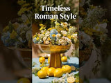 Colorful floral arrangement in a golden bowl with lemons, showcasing timeless Roman style.
